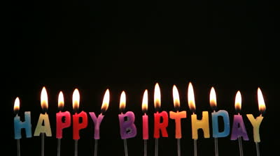 a candle against a black background burning and then being blown ...